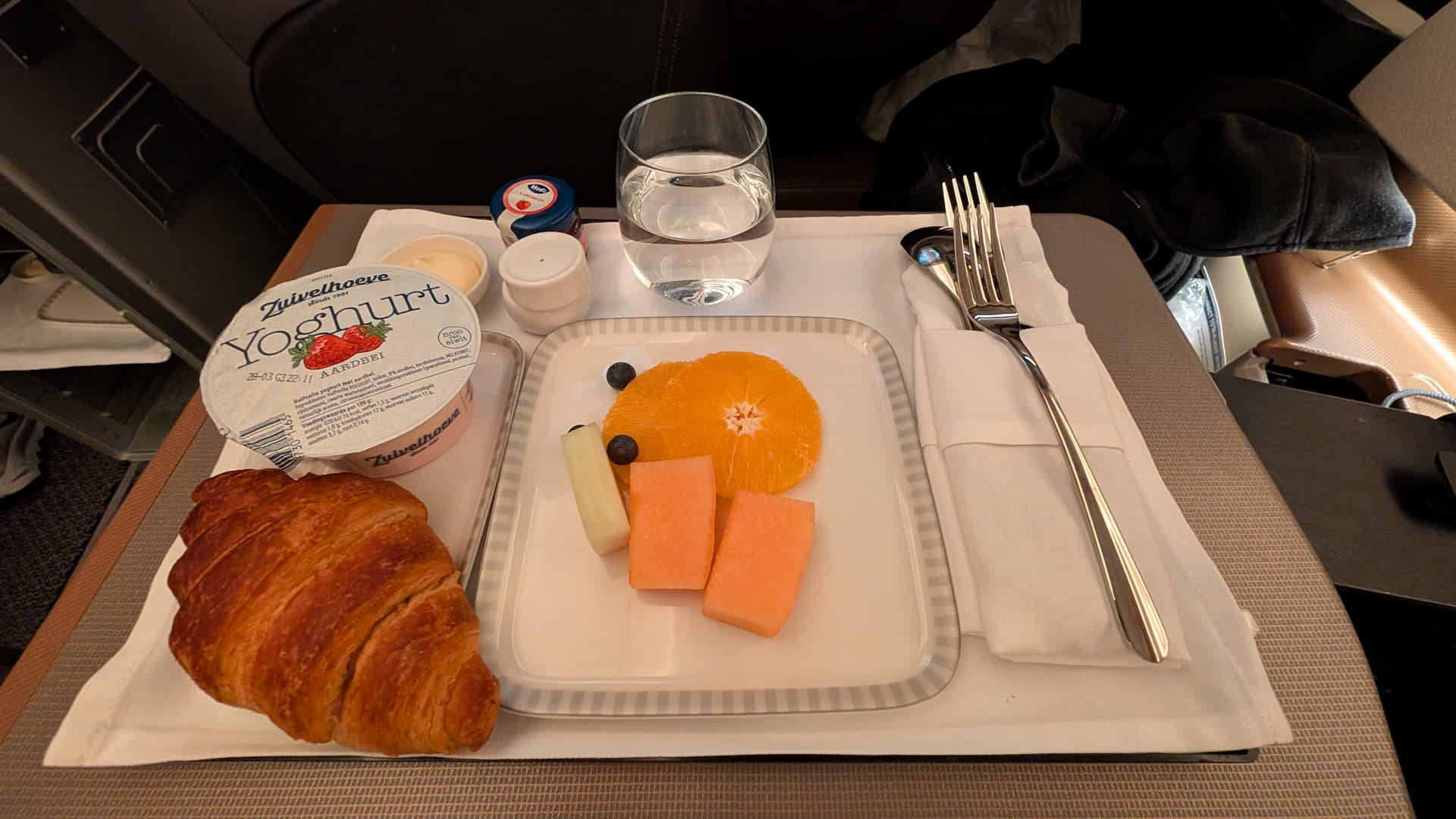 Frühstückstablett mit Croissant, Joghurt und Obst