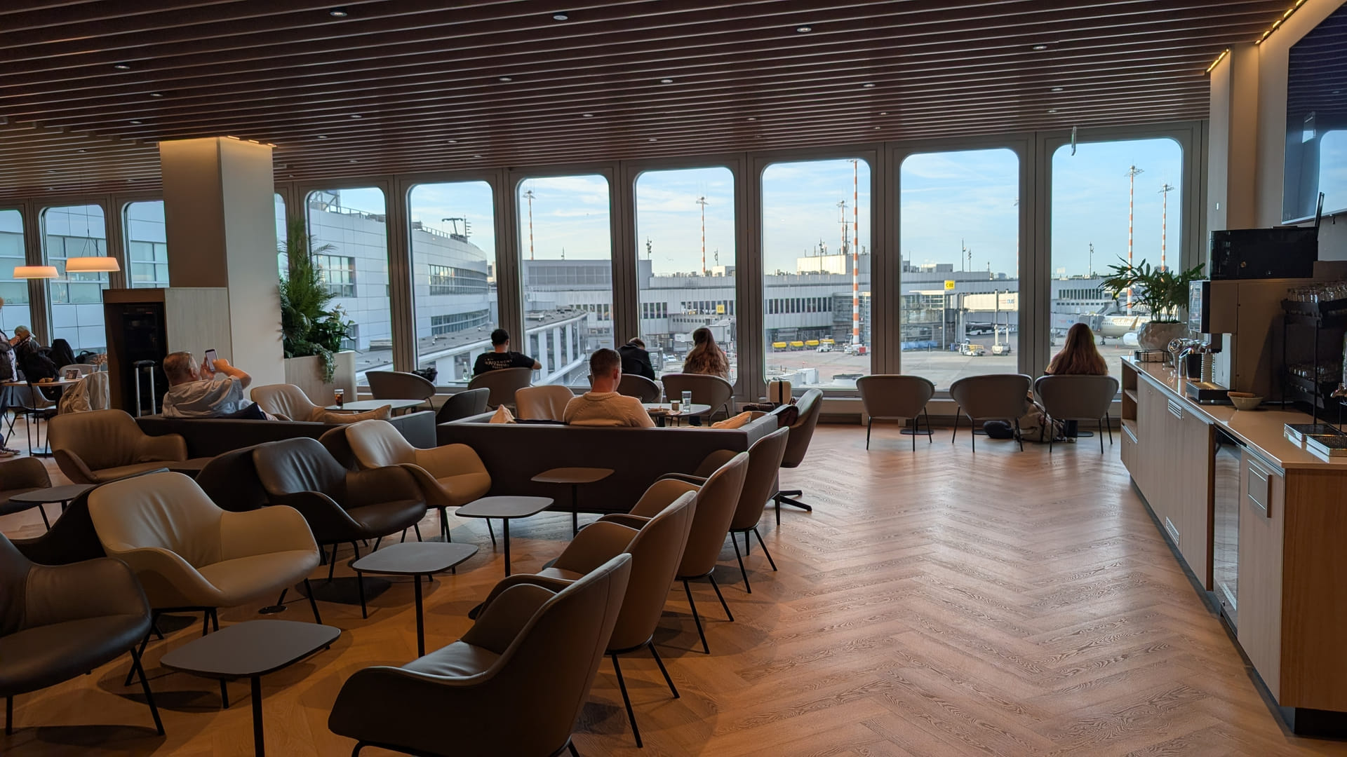 Loungebereich der neu gestalteten DUS Rhein Lounge am Flughafen Düsseldorf mit Sesseln und Fensterfront zum Vorfeld