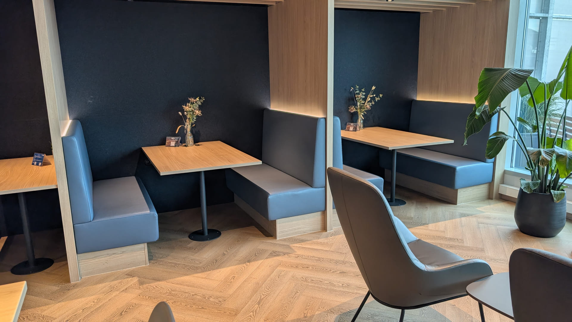 Sitznischen mit blauen Polsterbänken in der DUS Rhein Lounge