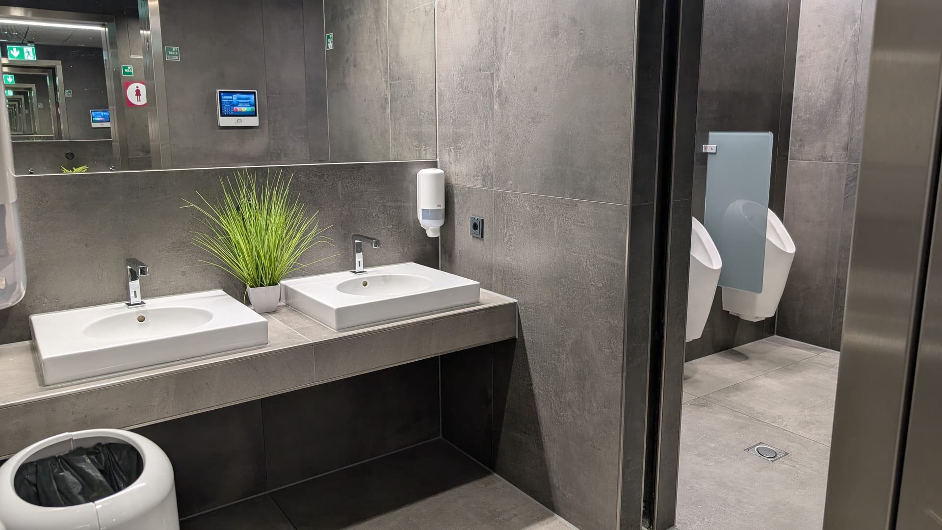 Neue Toiletten der DUS Rhein Lounge mit Waschbecken und dunklen Fliesen